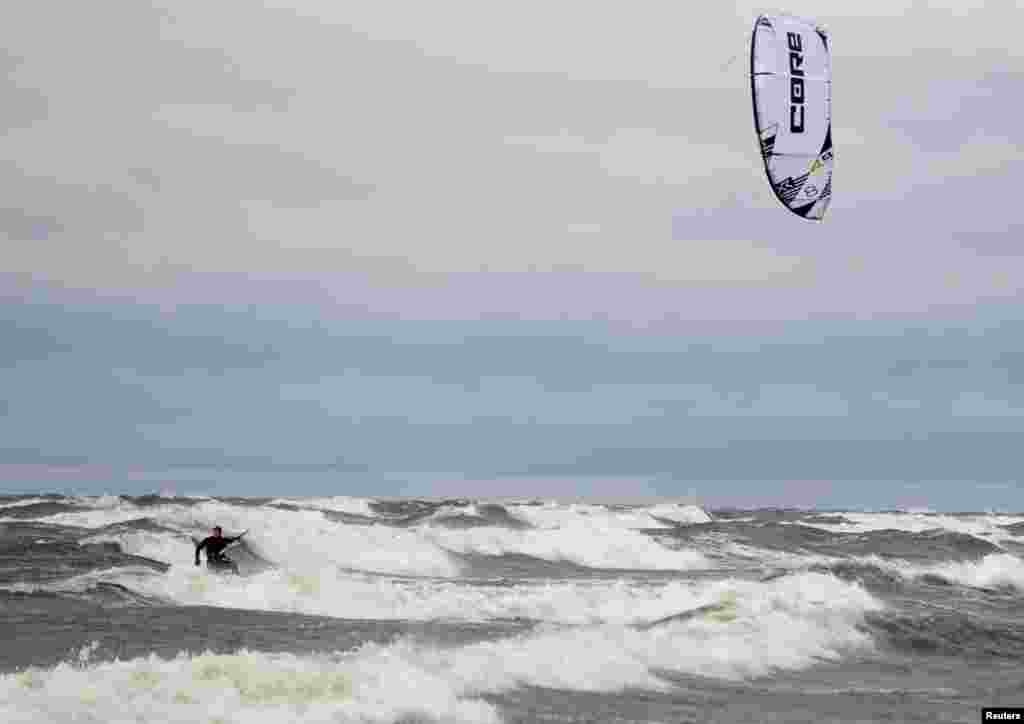 A man kiteboards during a windy day at seaside in Riga, Latvia.