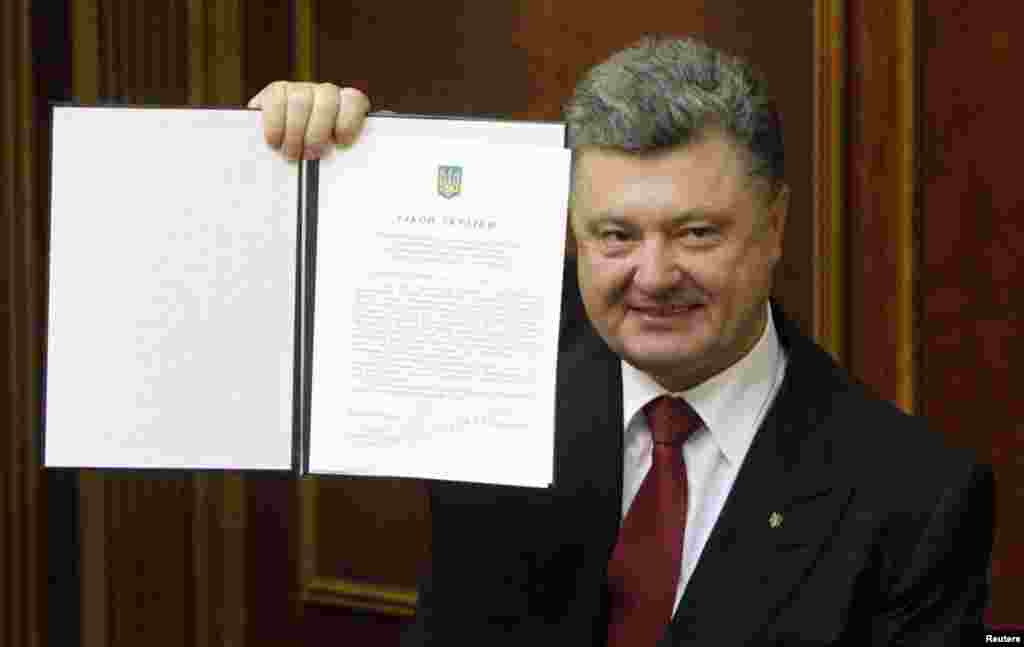 Ukraine's President Petro Poroshenko shows a signed landmark association agreement with the European Union during a session of the parliament in Kyiv, Sept. 16, 2014.