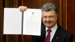 FILE: Ukraine's President Petro Poroshenko shows a signed landmark association agreement with the European Union during a session of the parliament in Kyiv, Sept. 16, 2014.