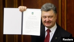 Ukraine's President Petro Poroshenko shows a signed landmark association agreement with the European Union during a session of the parliament in Kyiv, Sept. 16, 2014.