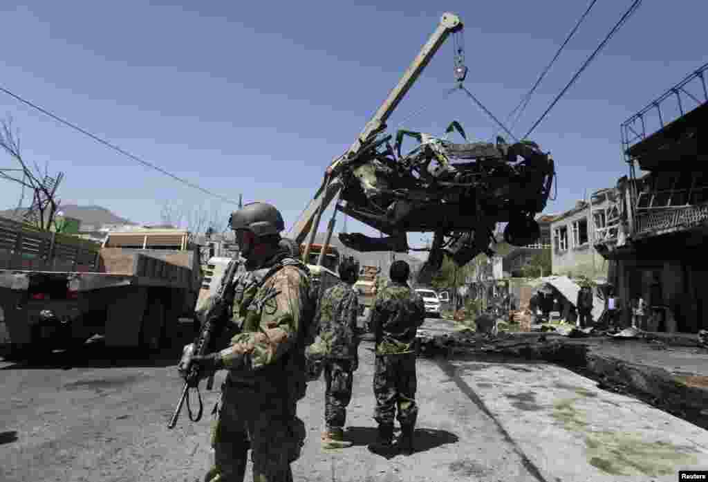 A NATO soldier with the International Security Assistance Force (ISAF) stand at the site of a suicide attack in Kabul, May 16, 2013.