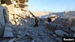 Residents inspect damage after airstrikes by pro-Syrian government forces in Anadan city, about 10 kilometers away from the towns of Nubul and Zahraa, Northern Aleppo countryside, Feb. 3, 2016.