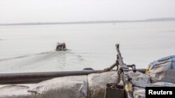 FILE - A machine gun is seen on a sandbag on a boat off the Atlantic coast in Nigeria's Bayelsa state December 19, 2013. To better guard their coasts, West African navies have partnered with countries like U.S., Britain and France.