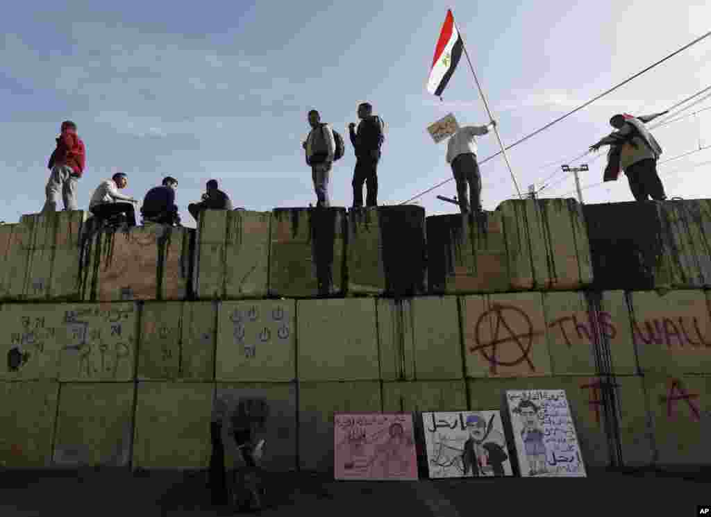 지난달 11일 이집트 카이로 대통령궁 외벽에 올라서서 무르시 반대를 외치는 시위대.