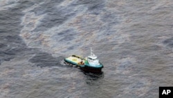 This photo taken Nov. 18, 2011 and released by Rio de Janeiro's government, shows an aerial view of a boat crossing an area of an oil spill in an offshore field operated by Chevron at the Bacia de Campos, in Rio de Janeiro state, Brazil.