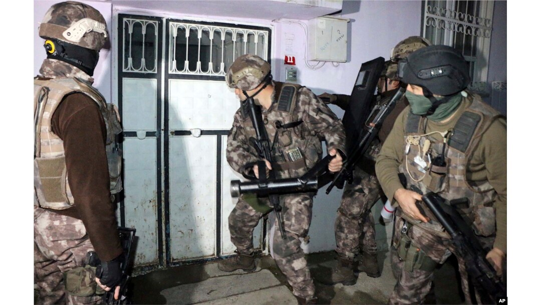 Turkish anti-terrorism police break a door during an operation to arrest people over alleged links to the Islamic State group, in Adiyaman, southeastern Turkey, Feb. 5, 2017.