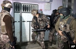 Turkish anti-terrorism police break a door during an operation to arrest people over alleged links to the Islamic State group, in Adiyaman, southeastern Turkey, Feb. 5, 2017.