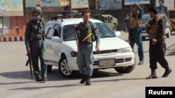 Afghan policemen keep watch in the downtown of Kunduz city, Afghanistan, Oct. 3, 2016.