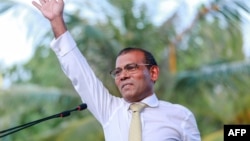 Former president of the Maldives Mohamed Nasheed waves as he addresses the country after returning from exile to the Maldives, in Male, Nov.18.