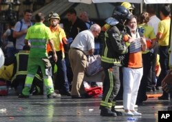 Injured people are treated in Barcelona, Spain, Aug. 17, 2017 after a van jumped the sidewalk in the historic Las Ramblas district, crashing into a summer crowd of residents and tourists.