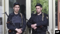 Russian police officers guard the entrance of the building where Russian opposition leader Alexei Navalny resides during a police search in Moscow, June 11, 2012. 