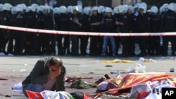 A man cries over the body of a victim, at the site of an explosion in Ankara, Oct. 10, 2015.