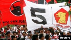 Para pendukung PDI Perjuangan (PDI-P) dan Partai Gerindra mengibarkan spanduk bendera partai, saat Megawati dan Prabowo Subianto mendaftar sebagai capres/cawapres ke KPU pada pemilu 2009, 16 Mei 2009. (Foto:dok)