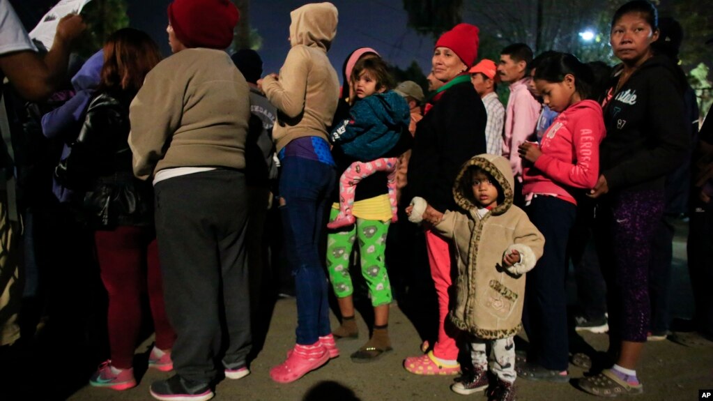 Mujeres y niños hacen fila para recibir alimentos y artículos de higiene donados en un complejo deportivo que sirve como refugio para más de 5,000 migrantes centroamericanos, en Tijuana, México, el martes 27 de noviembre de 2018.