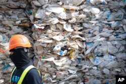 FILE - A container is filled with plastic waste from Australia, in Port Klang, Malaysia, May 28, 2019.