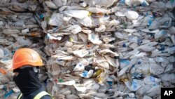 FILE - A container is filled with plastic waste from Australia, in Port Klang, Malaysia, May 28, 2019.