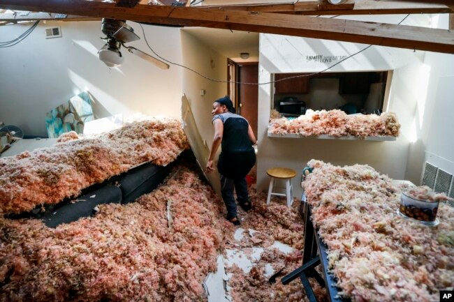 Erica Bohannon leads reporters through her destroyed apartment, May 28, 2019, in Trotwood, Ohio, after a tornado storm system passed through the area the night before, tearing her roof off while she huddled with her son and dog in her bedroom closet.