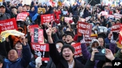 Upon hearing of President Park Geun-hye's impeachment, protesters celebrate in front of the National Assembly in Seoul, South Korea, Dec. 9, 2016.