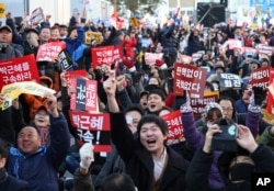 Protesters celebrate after hearing the news of President Park Geun-hye's impeachment in front of the National Assembly in Seoul, South Korea, Dec. 9, 2016.