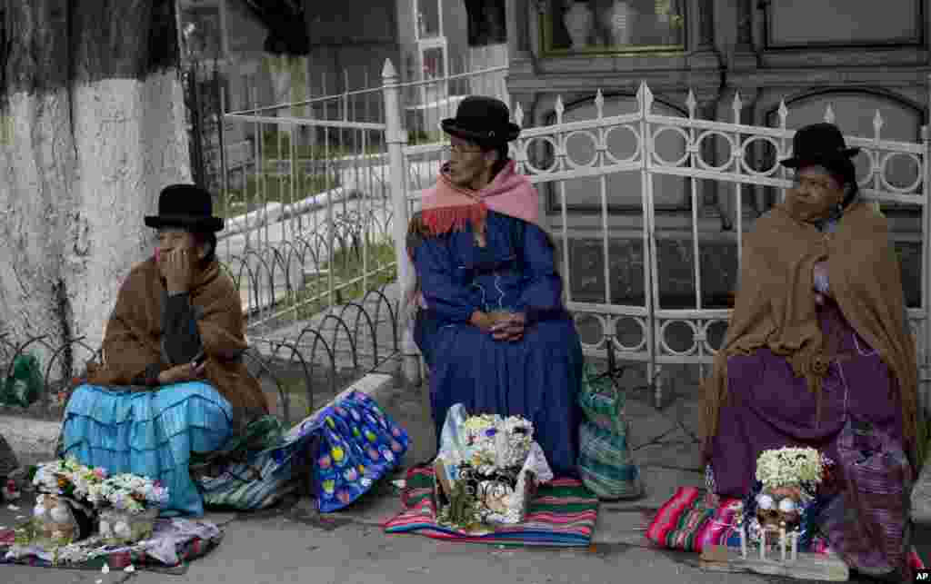Women sit with human skulls they decorated at the at the General Cemetery during the Natitas Festival, in La Paz, Bolivia. Celebrated a week after the Day of the Dead, Bolivians carry human skulls adorned with flowers to cemeteries asking for money, health, and other favors.