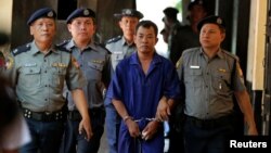 Detained Police Captain Moe Yan Naing is escorted by police after arriving for a court hearing in Yangon, Myanmar, May 9, 2018.