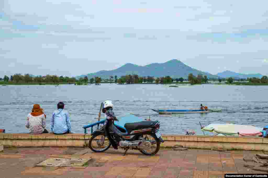 បុរសពីរនាក់អង្គុយលេងនៅមាត់ទន្លេទល់មុខភ្នំនាងកង្រី នៅក្រុងកំពង់ឆ្នាំង ខេត្តកំពង់ឆ្នាំង កាលពីថ្ងៃសៅរ៍ ទី១៥ ខែតុលា ឆ្នាំ២០១៦។ (មជ្ឈមណ្ឌលឯកសារកម្ពុជា/អ៊ូច មករា)