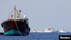China Coast Guard vessels patrol past a Chinese fishing vessel at the disputed Scarborough Shoal, April 5, 2017. Picture taken April 5, 2017. REUTERS/Erik De Castro