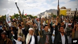 Shi'ite rebels known as Houthis hold up their weapons as they chant slogans during a rally against Saudi-led airstrikes in Sana'a, Yemen, Aug. 24, 2015.