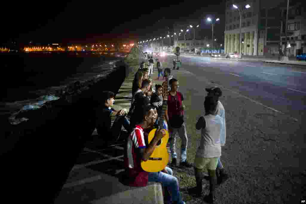 People gather along the Malecon seawall, as is customary on weekend nights, after President Raul Castro announced the death of his brother Fidel on national TV in Havana, Cuba, early Saturday, Nov. 26, 2016. 