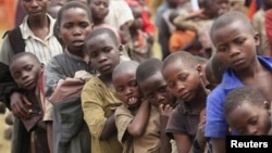 Refugee children, displaced by continued fighting in north Kivu province in the Democratic Republic of Congo, queue for food in the Nyakabande refugee transit camp in Kisoro town, July 13, 2012.