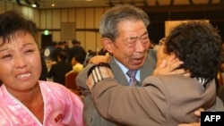 South Korean Min Ho-Sik, center, 84, hugs his North Korean relative Min Eun-Sik, right, 81, during a reunion meeting of family members separated after the Korean War at the Mount Kumgang resort on the North's southeastern coast, Oct. 20, 2015. 