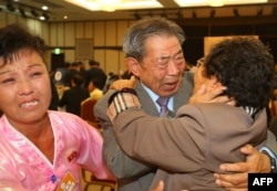 South Korean Min Ho-Sik, center, 84, hugs his North Korean relative Min Eun-Sik, right, 81, during a reunion meeting of family members separated after the Korean War at the Mount Kumgang resort on the North's southeastern coast, Oct. 20, 2015.