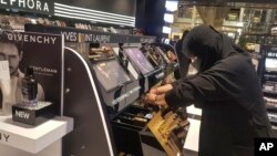 In this Thursday, April 19, 2018 photo, Najla Sultan bin Awwad works at Sephora in Riyadh. The mother of two in her 30s started working for the first time a year ago at the store, says even women who cover their face with a veil are becoming bolder in public.