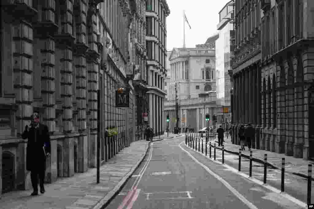 A man talks on the phone while walking in an empty street in the financial district, known as The City, in London.&nbsp;Many people will re-start working from home as the British government warns the rapid spread of omicron &quot;adds additional and rapidly increasing risk to the public and health care services.&quot;