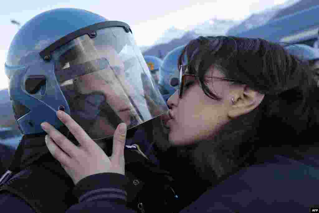 A demonstrator kisses a riot police officer during a protest in Susa against the high-speed train (TAV in Italian) line between Lyon and Turin, Nov. 16, 2013.