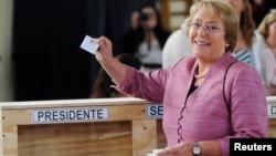 Chilean left-leaning opposition presidential candidate Michelle Bachelet shows her ballot during the presidential election in Santiago, Nov. 17, 2013.