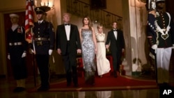 President Donald Trump, first lady Melania Trump, Brigitte Macron, and French President Emmanuel Macron walk down the Grand Staircase to pose for a photo in Grand Foyer before a State Dinner at the White House in Washington, April 24, 2018. 