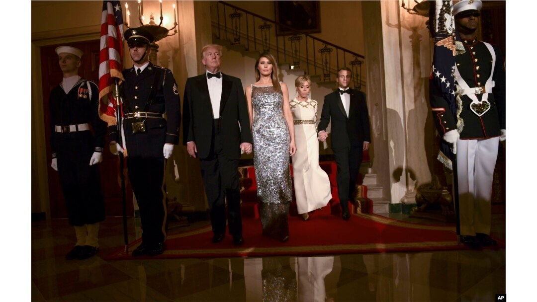 President Donald Trump, first lady Melania Trump, Brigitte Macron, and French President Emmanuel Macron walk down the Grand Staircase to pose for a photo in Grand Foyer before a State Dinner at the White House in Washington, April 24, 2018.