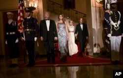 President Donald Trump, first lady Melania Trump, Brigitte Macron, and French President Emmanuel Macron walk down the Grand Staircase to pose for a photo in Grand Foyer before a State Dinner at the White House in Washington, April 24, 2018.