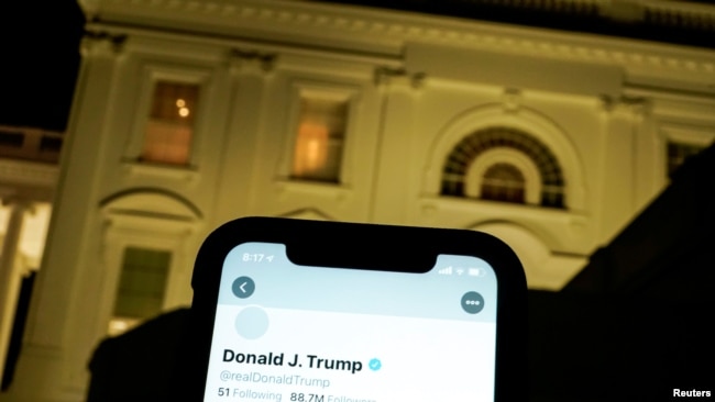 A photo illustration shows the suspended Twitter account of U.S. President Donald Trump on a smartphone and the White House in Washington, U.S., January 8, 2021. REUTERS/Joshua Roberts