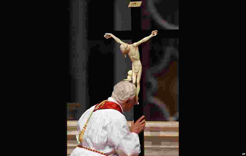Pope Benedict kisses the cross as he leads the Good Friday Passion Mass in Saint Peter's Basilica at the Vatican. (Reuters) 