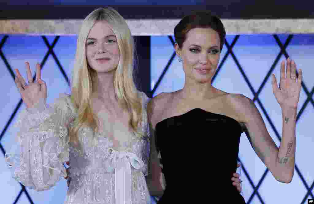 Actresses Angelina Jolie, right, and Elle Fanning wave during the premiere of &quot;Maleficent&quot; in Tokyo, Japan.