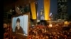 Pro-democracy protestors watch formal talks between student protest leaders and city officials on a video screen near the government headquarters in Hong Kong, Oct. 21, 2014.