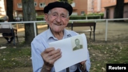 Maximino San Miguel, 102, holds a picture of himself when he was young as he poses for a portrait in a park near his home in Leon, northern Spain, Sept. 3, 2016