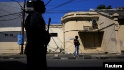 Anti-terror policemen stand guard following a bomb blast at a police office in Surabaya, Indonesia, May 14, 2018. 