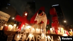 A protester from the CNTE teachers union places candles in front of a monument of the number 43 during a vigil following recent clashes between police and union members, in Mexico City, June 20, 2016. The number 43 represents the 43 missing students of the Ayotzinapa teacher training college.