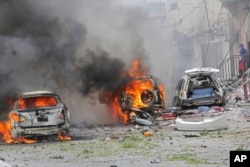Burning vehicles are seen outside Midnimo mall after a car bomb attack on a popular mall in Mogadishu, Somalia, July 30, 2017.