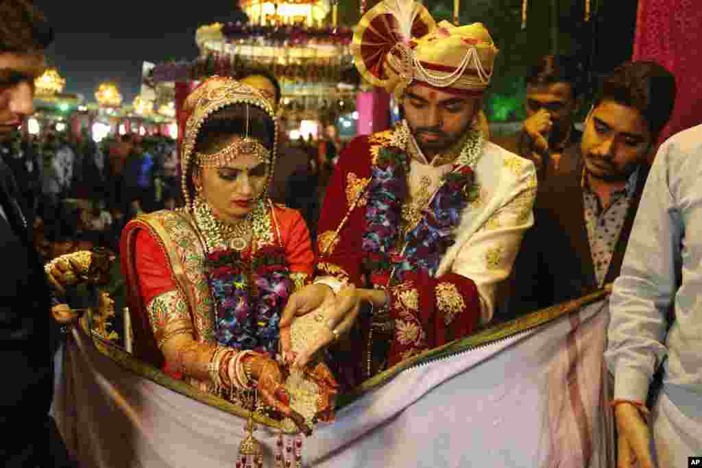 A bride and a groom perform rituals during a mass wedding in Surat, India.