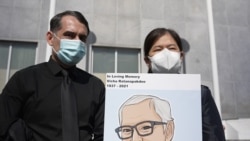 Monthanus Ratanapakdee (R) who holds a photograph of her late father Vicha Ratanapakdee and husband Eric Lawson (L) , during a rally for Vicha outside the Hall of Justice, SF, March 4, 2021