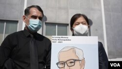 Monthanus Ratanapakdee (R) who holds a photograph of her late father Vicha Ratanapakdee and husband Eric Lawson (L) , during a rally for Vicha outside the Hall of Justice, SF, March 4, 2021